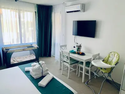 a room with a bed and a table and a desk at BAMBOO BEACH STUDIO- Sozopol in Sozopol