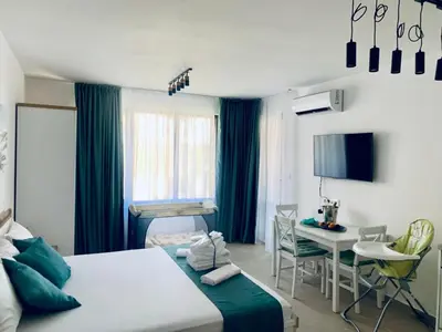 a bedroom with a bed and a desk and a table at BAMBOO BEACH STUDIO- Sozopol in Sozopol