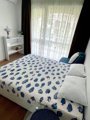 a bedroom with a bed with a blue and white comforter at Cozy apartment on Sunny Beach in Sunny Beach