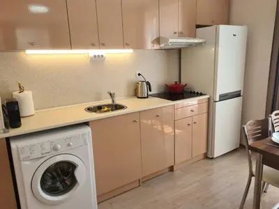 a kitchen with a washing machine and a refrigerator at Messembria Palace in Sunny Beach