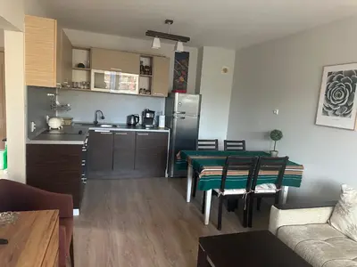 a kitchen and living room with a table and a refrigerator at Kalia A7 Sunny Beach in Bŭnzareto