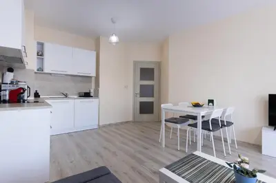 a kitchen and dining room with a white table and chairs at ViolaSuite in Varna South Bay by RV Apartments in Varna City