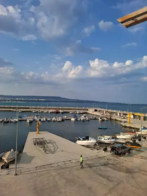a marina with boats in the water and two people at ViolaSuite in Varna South Bay by RV Apartments in Varna City