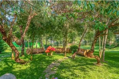a park with trees and benches in the grass at Harmony Suites Grand Resort 16 in Sunny Beach