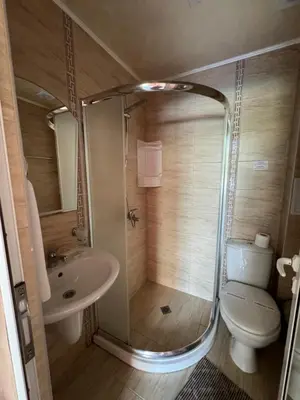 a bathroom with a shower and a toilet and a sink at HOLIDAY Suites at Sunny Beach in Sunny Beach