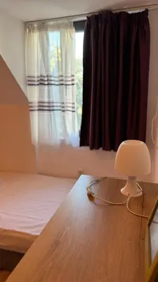 a room with a bed and a table and a window at Harbour Top-View Terrace 2-BDR Central Apartment in Varna City