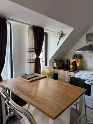a kitchen with a wooden table and chairs at Harbour Top-View Terrace 2-BDR Central Apartment in Varna City