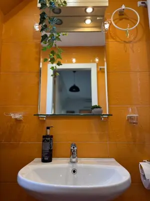 a bathroom with a sink and a mirror at Harbour Top-View Terrace 2-BDR Central Apartment in Varna City