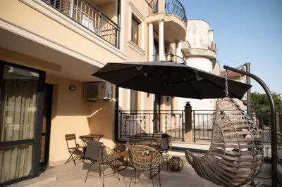 a patio with chairs and an umbrella on a balcony at Spirit apartment in Burgas City