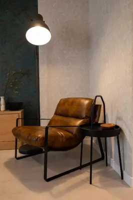 a brown leather chair and a table in a room at Spirit apartment in Burgas City