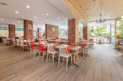 a dining room with tables and chairs in a restaurant at All-inclusive Holiday Apartments in Tarsis Hotel & Aquapark in Sunny Beach