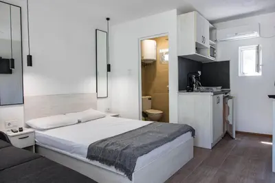 a bedroom with a large white bed and a couch at Къмпинг Албатрос in Varna City