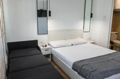 a small bedroom with a bed and a bench at Къмпинг Албатрос in Varna City