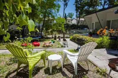 three chairs and a table in a garden at Къмпинг Албатрос in Varna City