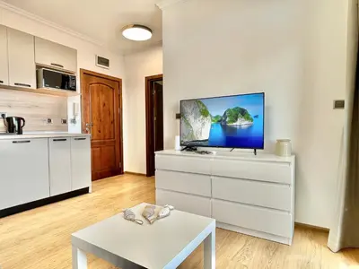 a living room with a tv on a white dresser at Tryavna Beach - Private apartment - BSR - 4 in Sveti Vlas
