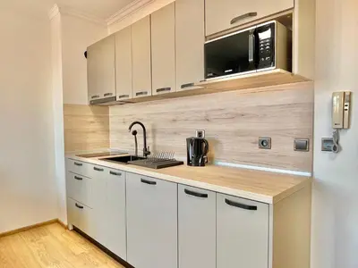 a kitchen with white cabinets and a microwave at Tryavna Beach - Private apartment - BSR - 4 in Sveti Vlas