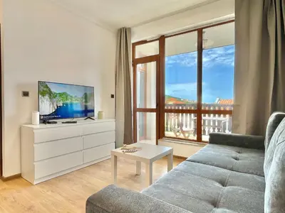 a living room with a couch and a tv at Tryavna Beach - Private apartment - BSR - 4 in Sveti Vlas