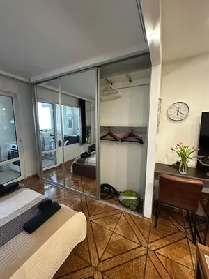 a bedroom with a bed and a clock on the wall at Zornitsa View in Burgas City
