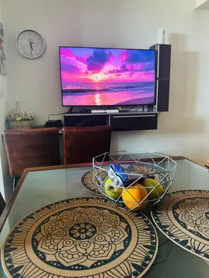 a table with a bowl of fruit and a television at Zornitsa View in Burgas City