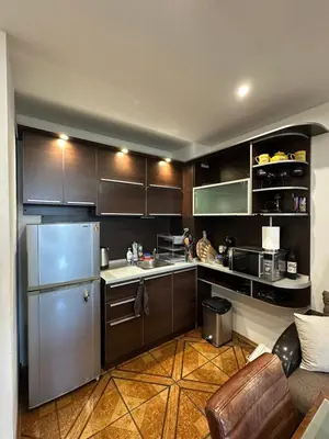 a kitchen with brown cabinets and a stainless steel refrigerator at Zornitsa View in Burgas City