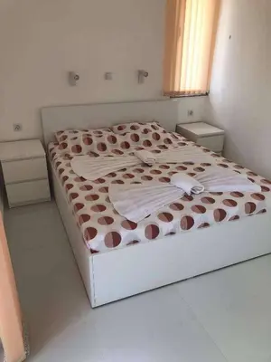 a bedroom with a bed with a brown and white comforter at Blue Magenta 1 in Sozopol