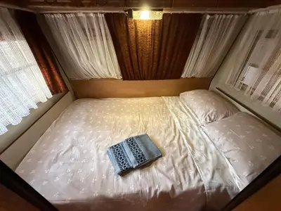 a bed with a book on top of it at Каравана Мир in Chernomorets
