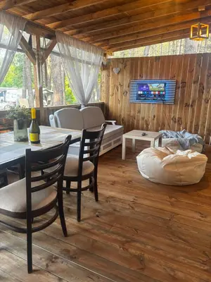 a living room with a table and chairs and a tv at Каравана Мир in Chernomorets