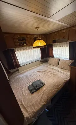 a bed in a small room with a lamp on it at Каравана Мир in Chernomorets