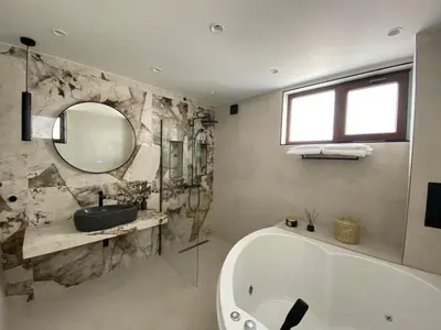 a bathroom with a tub and a sink and a mirror at Luxurious house Sarafovo beach in Burgas City