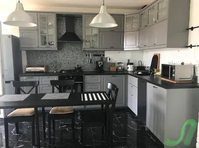 a kitchen with white cabinets and a table with chairs at Burgas Center in Burgas City