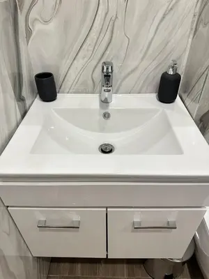 a white bathroom sink with two black cups on it at Chantrer in Burgas City
