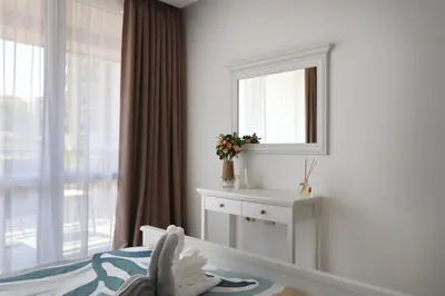 a bedroom with a mirror and a bed and a window at Stylish Paradiso Apartment 206 in Nesebar