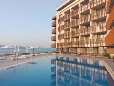 a hotel with a swimming pool in front of a building at Stylish Paradiso Apartment 206 in Nesebar