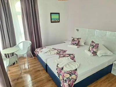 a bedroom with a bed and a table and chairs at Chance Sarafovo in Burgas City