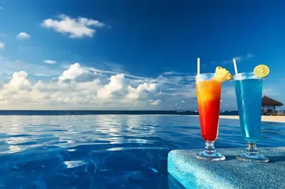 two cocktails sitting on the edge of a swimming pool at Funny-Gunny Room to The Sea Garden in Burgas City