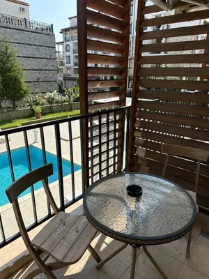 a table and chairs on a balcony with a pool at Студио до плажа Свети Влас in Sveti Vlas