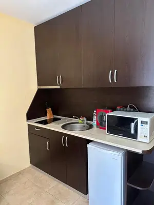 a small kitchen with a sink and a microwave at Студио до плажа Свети Влас in Sveti Vlas