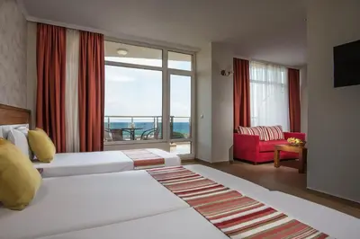 a hotel room with two beds and a large window at Hotel Miramar Sozopol in Sozopol