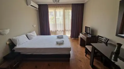 a bedroom with a bed and a desk and a television at MitProt Panorama Bay 2 Studio 67 in Sveti Vlas