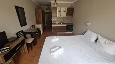 a bedroom with a white bed and a kitchen at MitProt Panorama Bay 2 Studio 67 in Sveti Vlas