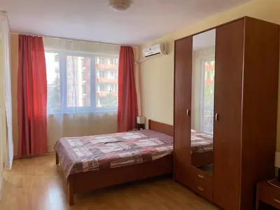 a bedroom with a bed and a cabinet and a window at Amartmán přímo u moře - Elenite in Sveti Vlas
