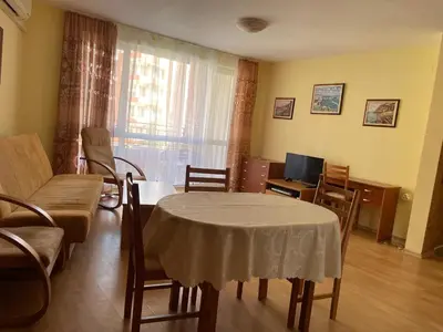 a living room with a table and chairs and a television at Amartmán přímo u moře - Elenite in Sveti Vlas