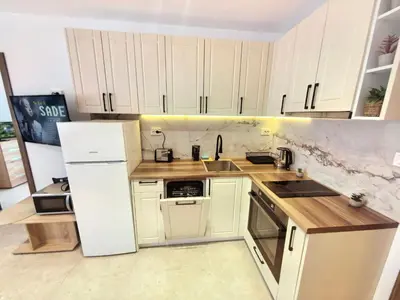 a kitchen with white cabinets and a white refrigerator at Sunny Dream Family Apartment in Sunny Beach