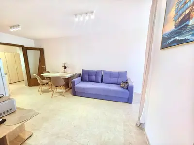 a living room with a blue couch and a table at Sunny Dream Family Apartment in Sunny Beach