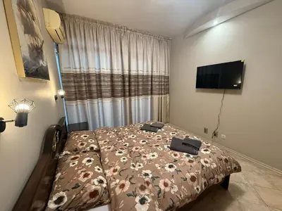 a bedroom with a bed and a flat screen tv at YS Platinum Residence in Sunny Beach