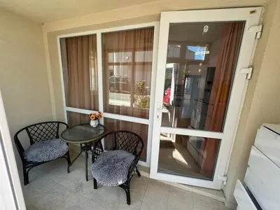 a balcony with a table and chairs and a glass door at Sunny Day 7 in Burgas City