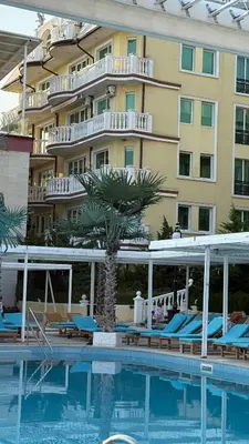 a hotel with a swimming pool in front of a building at Апартамент в КК 