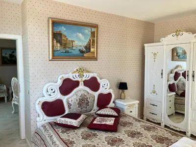a bedroom with a bed and a painting on the wall at Апартамент в КК 