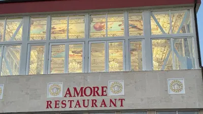 a building with a more restaurant sign and windows at Апартамент в КК 