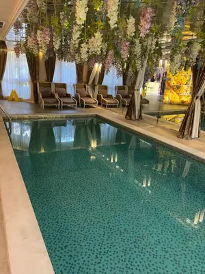 a swimming pool in a hotel with chairs and flowers at Schöne Ferienwohnung im Harmony Suites Monte Carlo in Sunny Beach